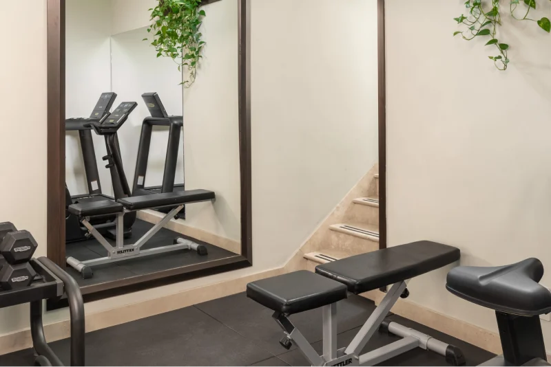 Modern fitness room with mirrors, weights and cardio equipment to stay fit during your stay - Hotel Diocleziano, BZAR hotels in Rome